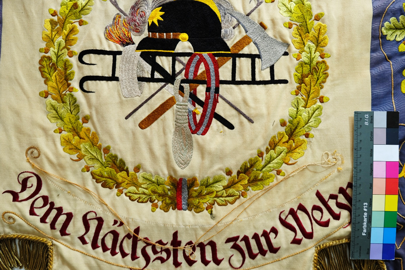 Feuerwehrfahne, gelöste 
Stickerei und Schriftzüge vor der Restaurierung.
Foto: ©Textilrestaurierung Lyko, 
Eigentümer: Feuerwehr Großen-Buseck 