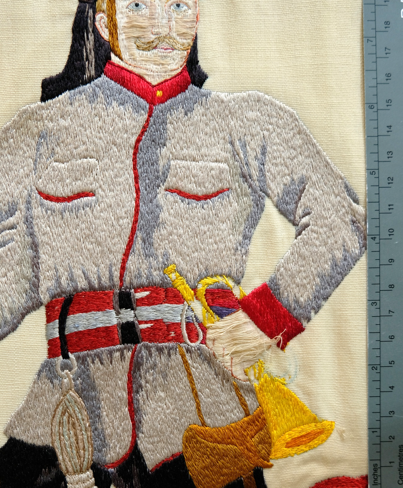 Feuerwehrfahne, gelöste Applikationen vor der Restaurierung. Foto: ©Textilrestaurierung Lyko, 
Eigentümer: Feuerwehr Großen-Buseck  